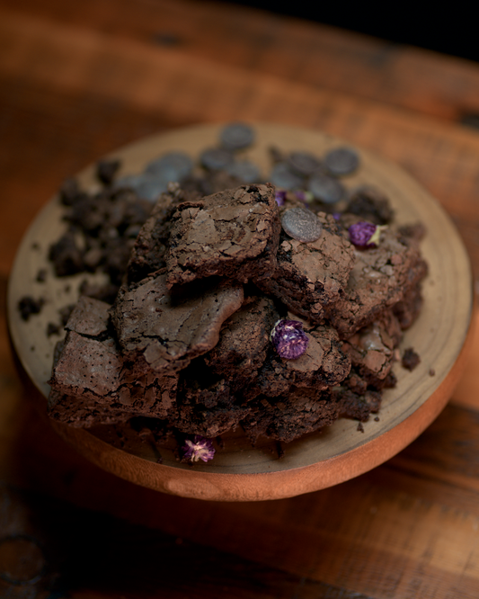 Designer placeholder: premium product photography for Decadent Gluten-Free Brownies styled on cream linen with warm bakery lighting.