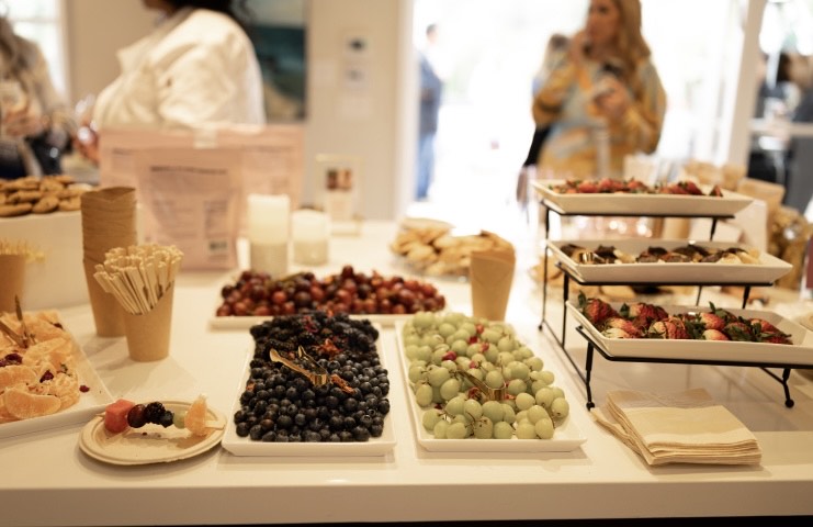 Designer placeholder: abundant event catering spread with gluten-free desserts, fresh ingredients, florals, and luxury presentation.