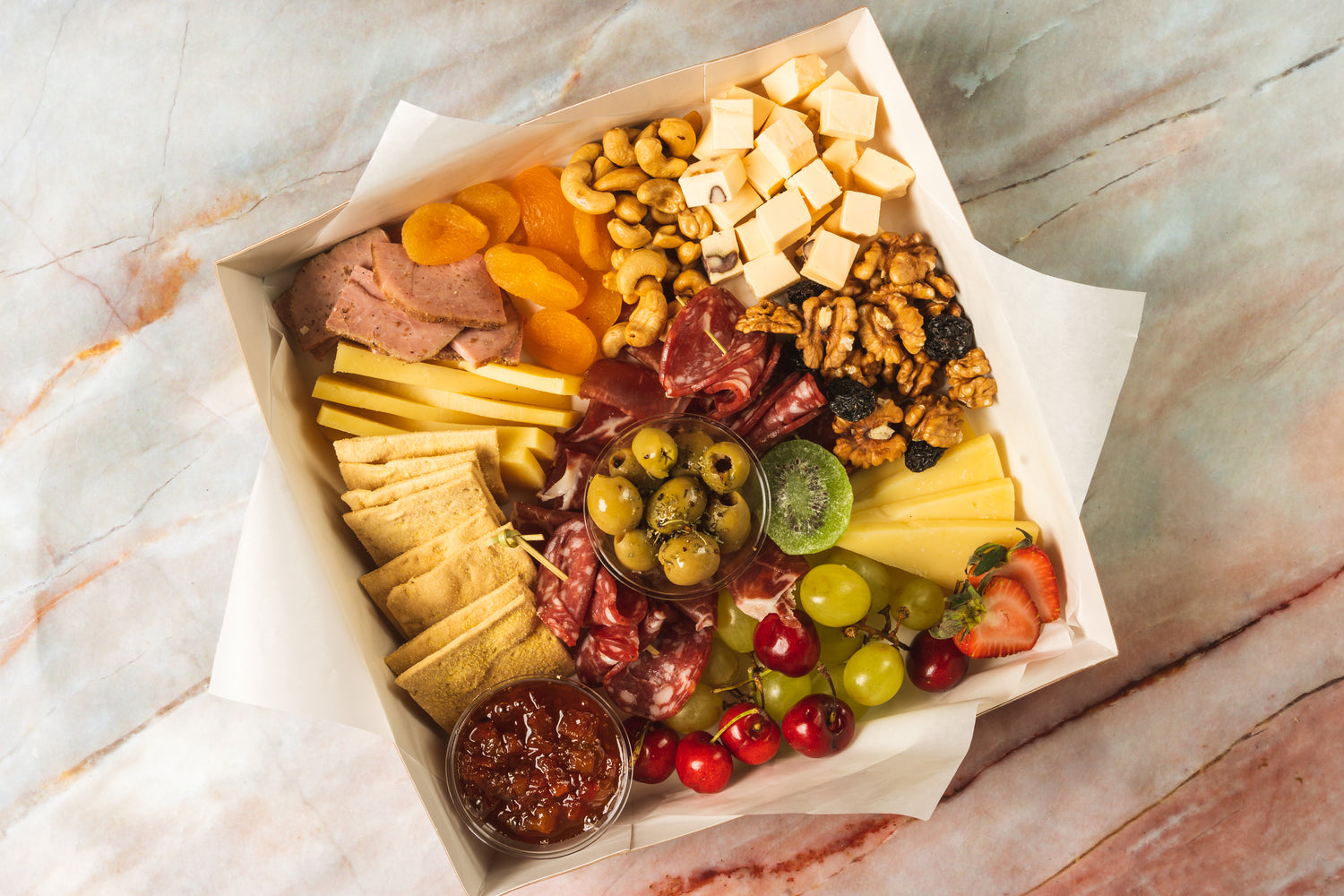 Designer placeholder: luxury charcuterie box with cheeses, fruit, herbs, crackers, and vegan/non-vegan options.