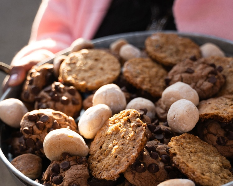 Designer placeholder: close-up luxury gluten-free dessert box with cookies, brownies, and powdered bites in warm natural light.